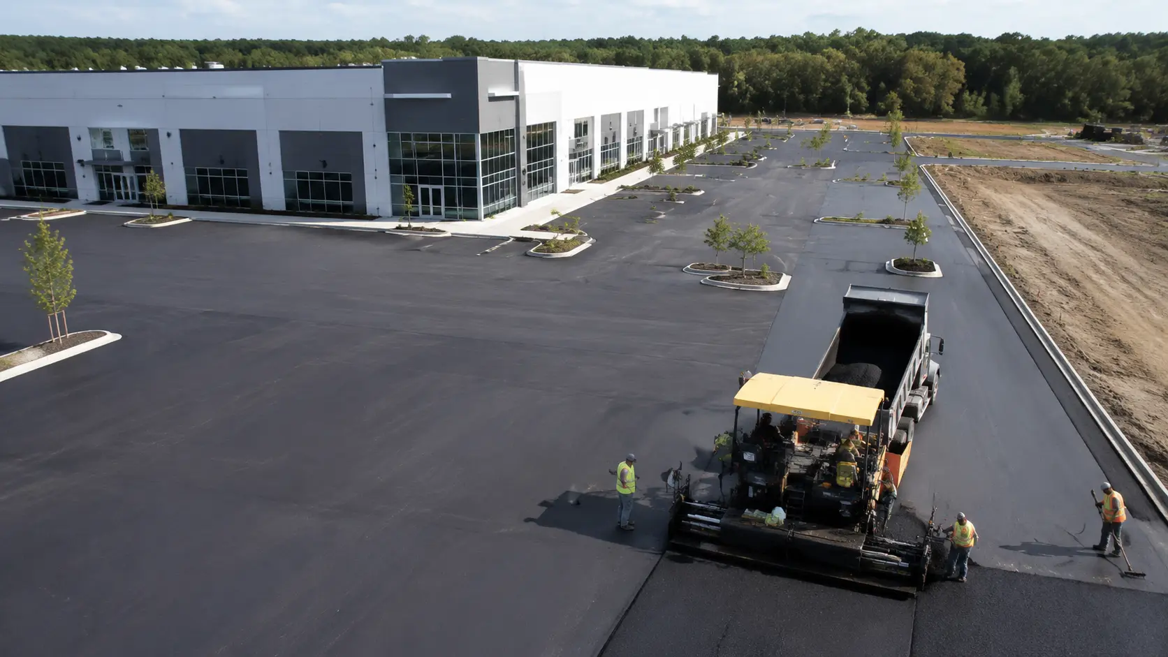 Asphalt paving equipment working on a commercial parking lot